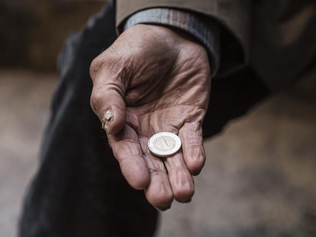homeless-man-holding-coin-his-hand.jpeg